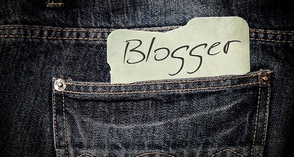 In der Gesäßtasche einer Jeans steckt eine Karte mit der Aufschrift Blogger