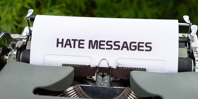 In einer Schreibmaschine steckt ein Blatt mit dem Text "Hate Messages".