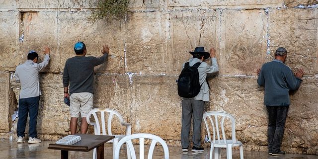 vier Juden berühren die Klagemauer in Jerusalem
